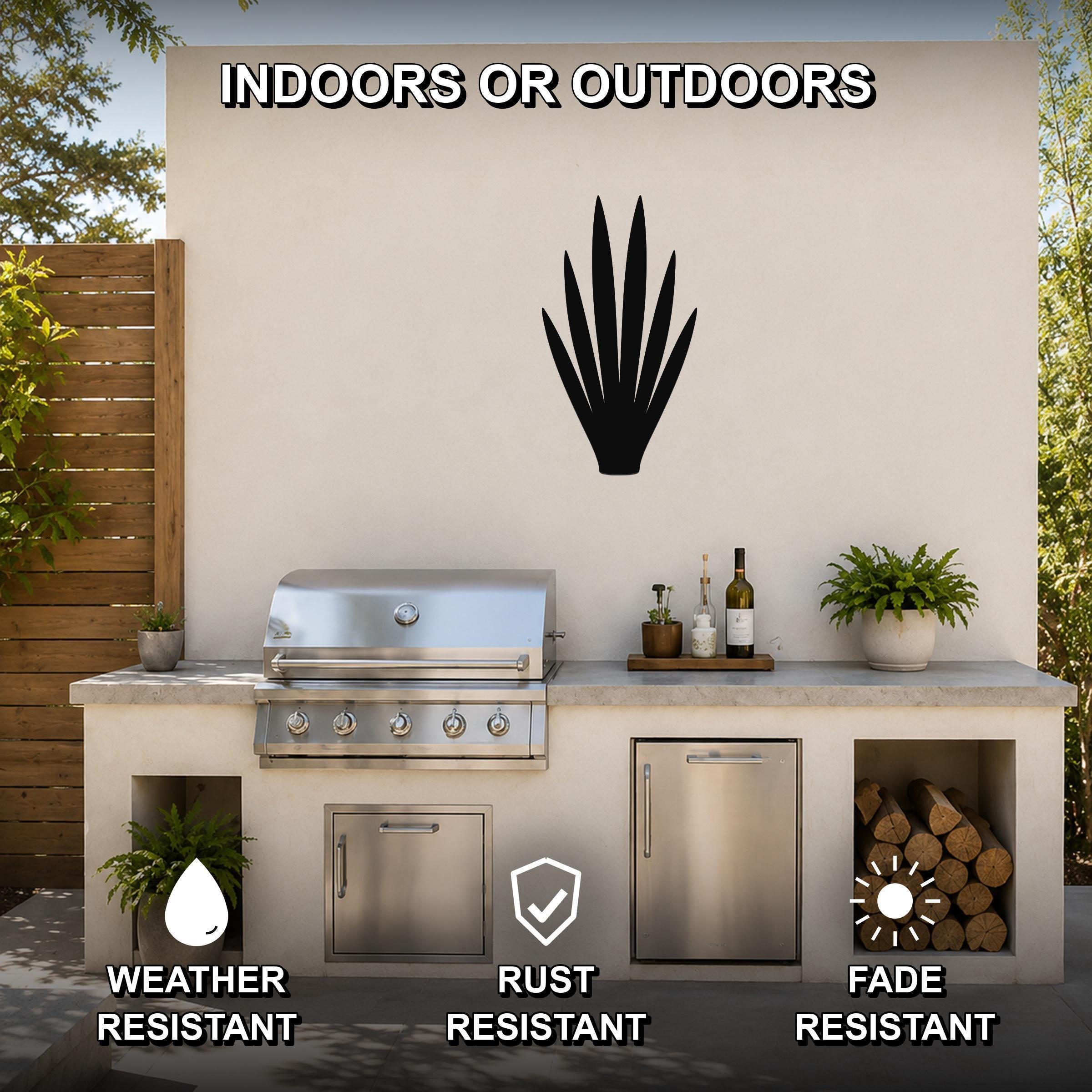 Black metal yucca wall art silhouette mounted on an outdoor patio wall above a stainless steel grill and countertop.