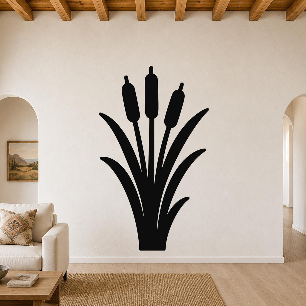 Black metal cattail wall art silhouette with three seed heads and long leaves, mounted on a living room wall above a sofa.