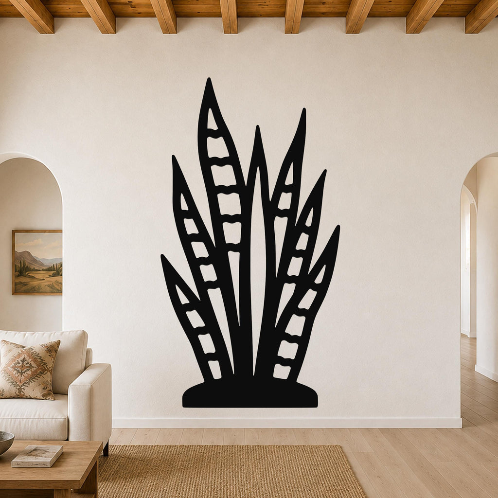 Black metal snake plant wall art with leaf cutouts, mounted on a living room wall above a sofa.