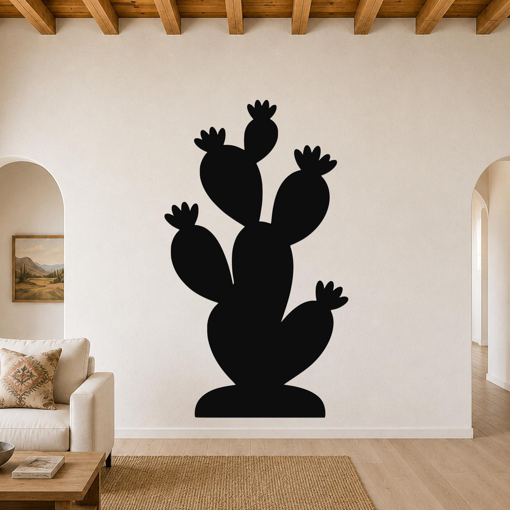 Black metal cactus wall art with multiple paddle-shaped arms and flower cutouts, mounted on a living room wall above a sofa.