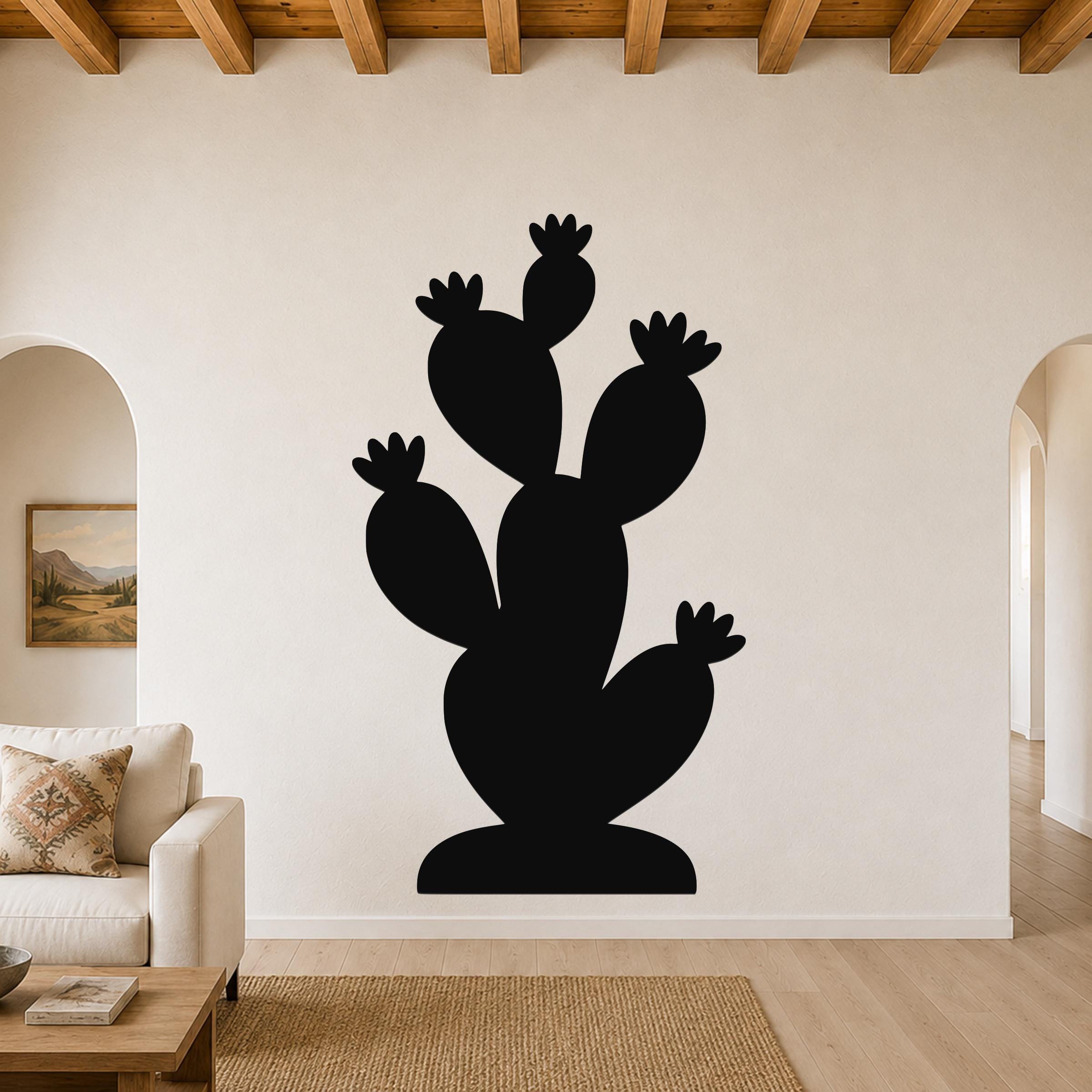 Black metal cactus wall art with multiple paddle-shaped arms and flower cutouts, mounted on a living room wall above a sofa.
