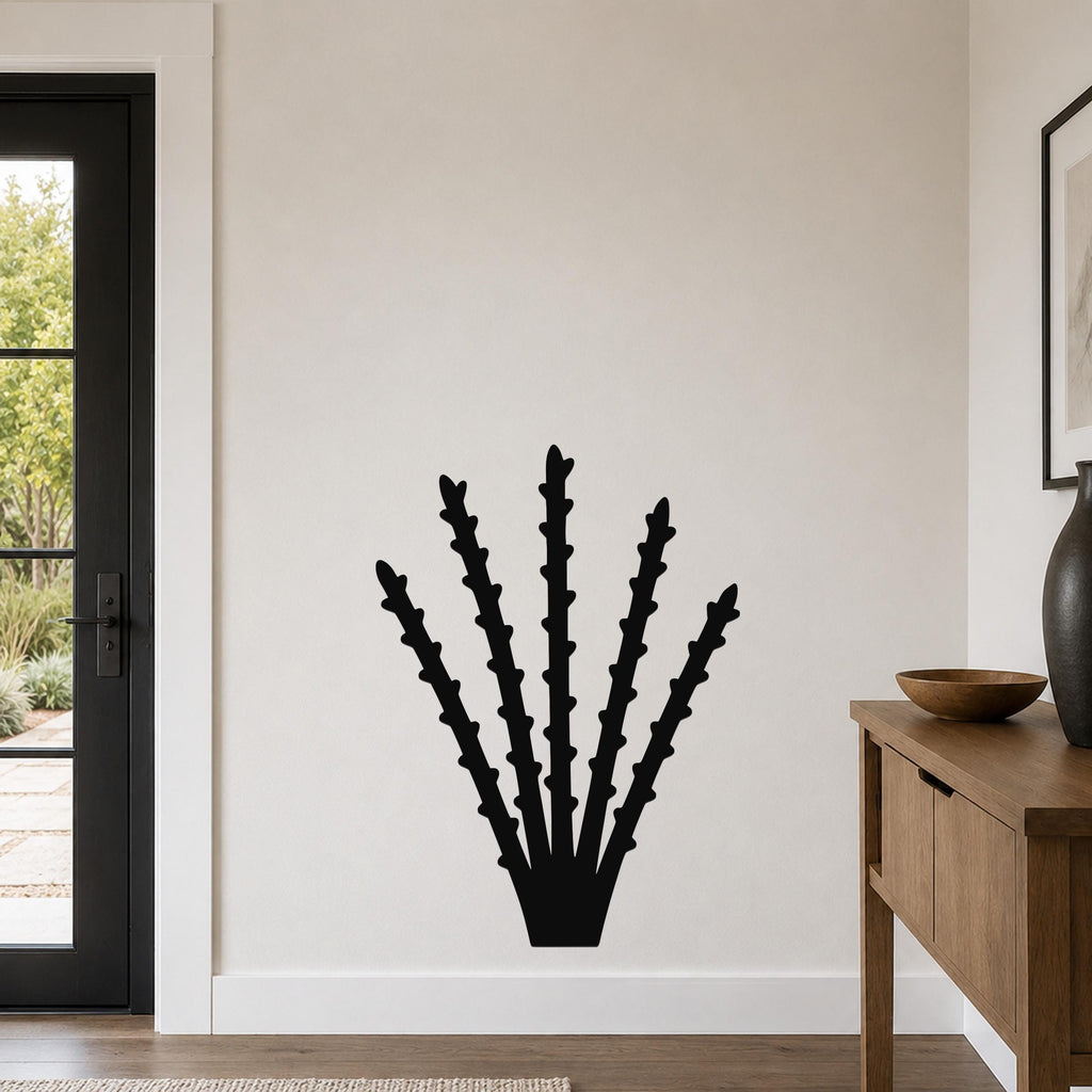 Black metal ocotillo wall art with spiky branch cutouts, mounted on a living room wall above a wooden console table.