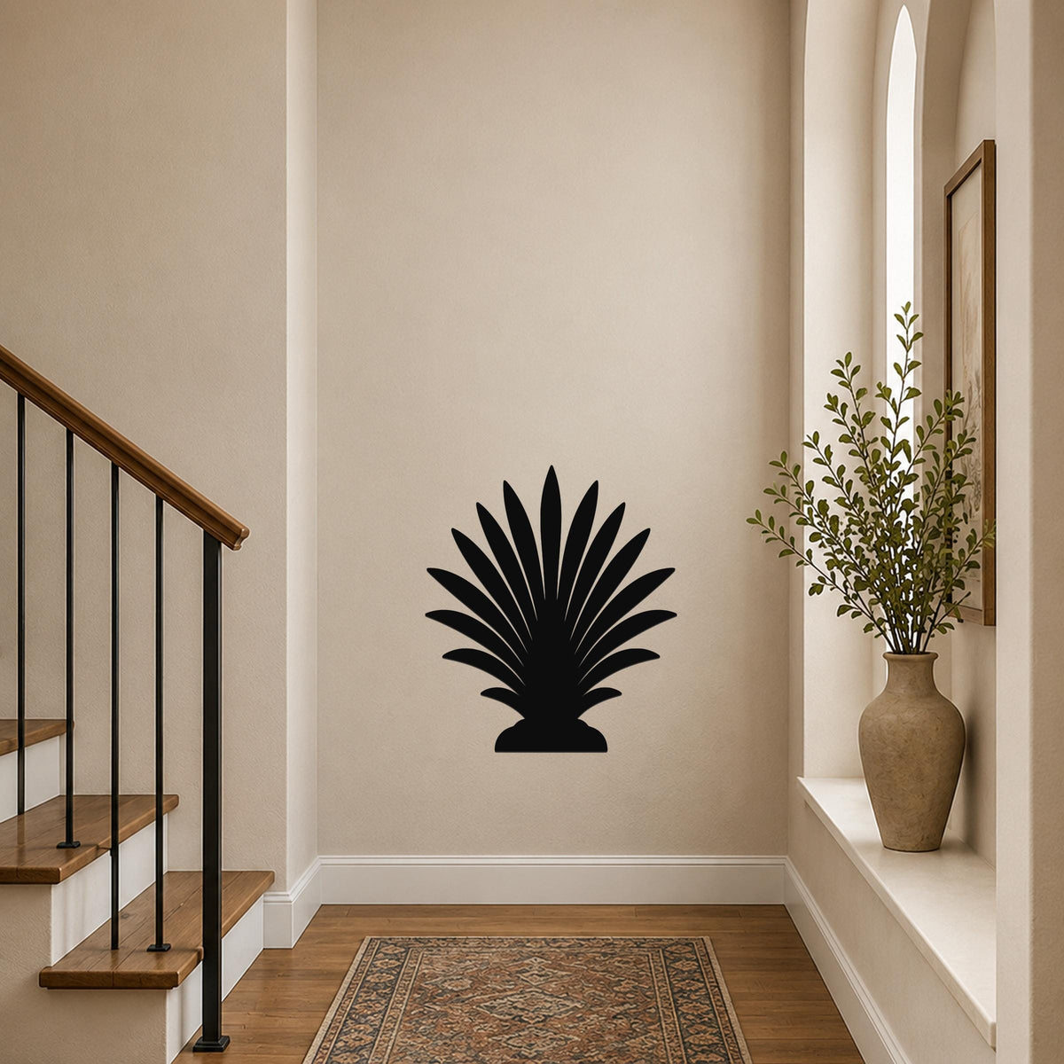Black metal palm tree wall art with fan-shaped fronds, mounted on a hallway wall above a patterned rug near a staircase.