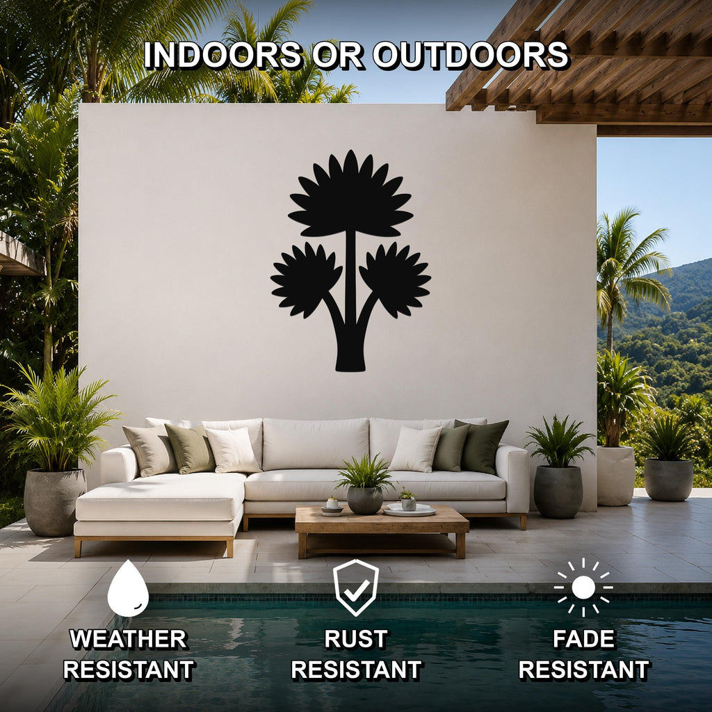 Black metal wall art featuring a fan palm tree silhouette, mounted on a white outdoor wall above a sofa in a patio living area.