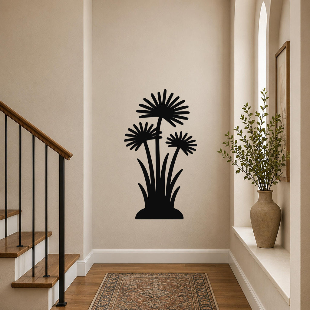 Black metal wall art featuring a silhouette of three daisy-like flowers with long stems and leaves, mounted on a hallway wall above a patterned rug near a staircase.