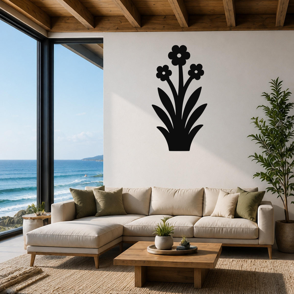 Black metal wall art with a wildflower silhouette, mounted above a beige sectional sofa in a living room with ocean views.