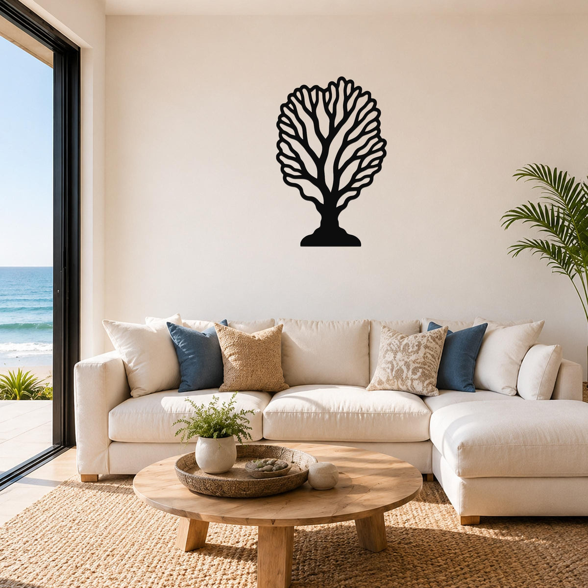 Black metal fan coral wall art with intricate branch cutouts, mounted on a living room wall above a white sofa.