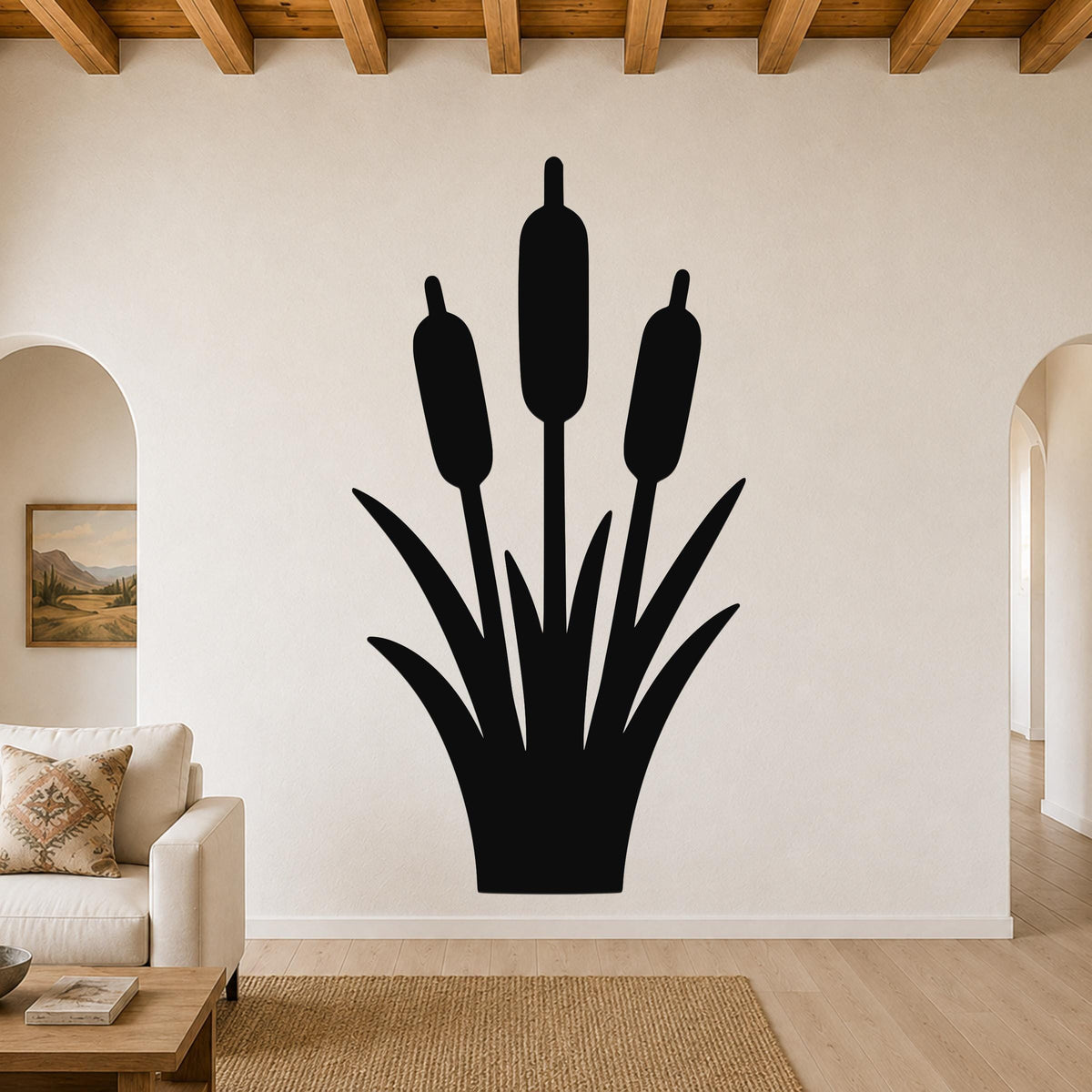 Black metal wall art silhouette of cattails with three seed heads and leafy base, mounted on a living room wall above a sofa.