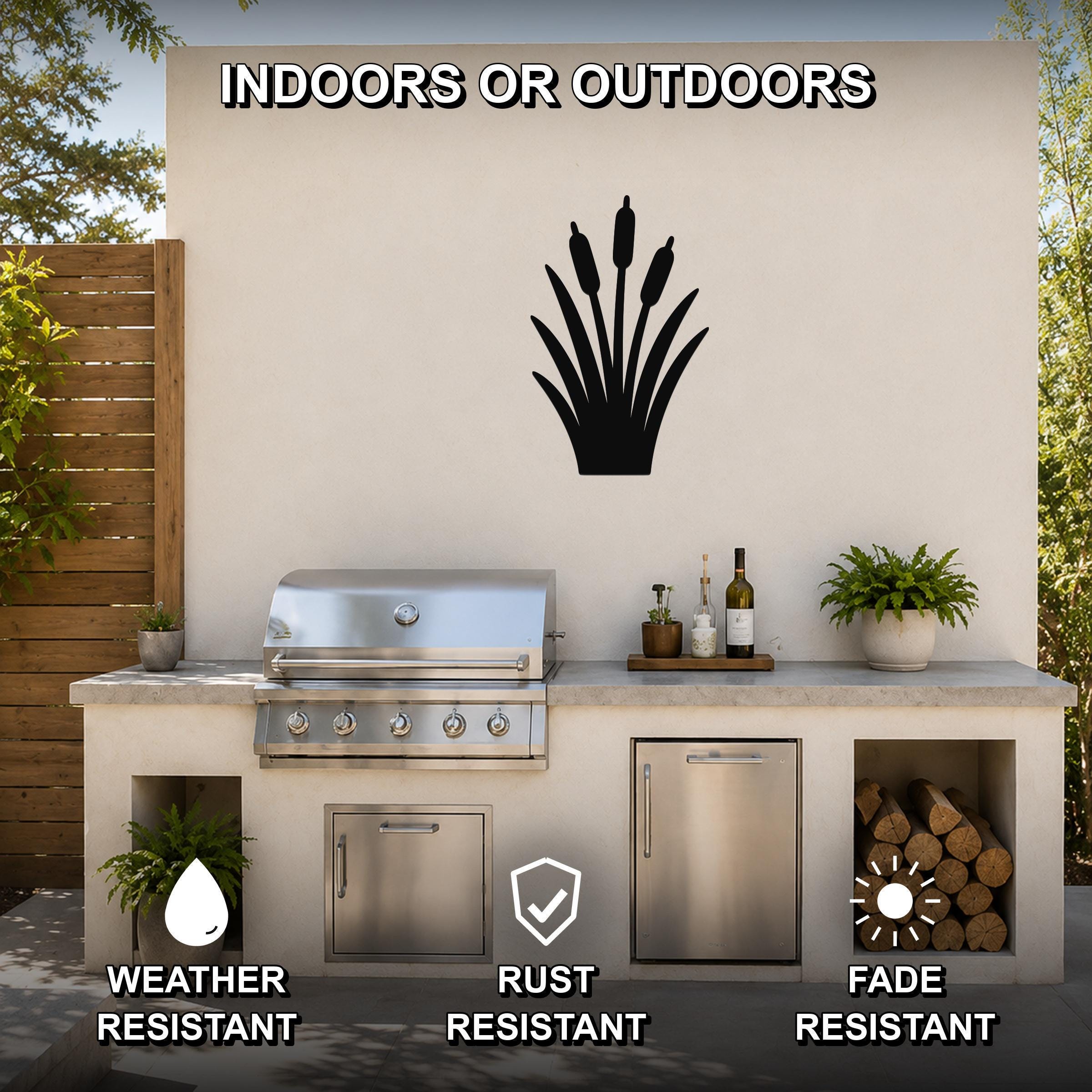 Black metal cattail wall art silhouette mounted on an outdoor patio wall above a stainless steel grill and countertop.
