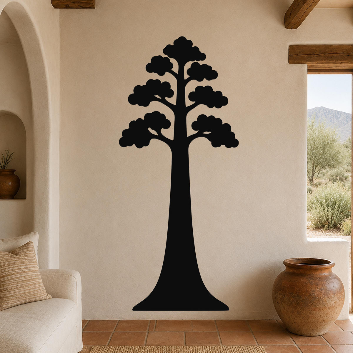 Black metal sequoia tree wall art with layered canopy cutouts, mounted on a beige living room wall above a sofa.