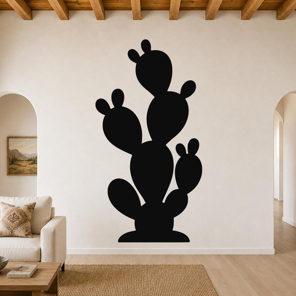 Black metal prickly pear cactus wall art with multiple pads and cutout details, mounted on a living room wall above a sofa.