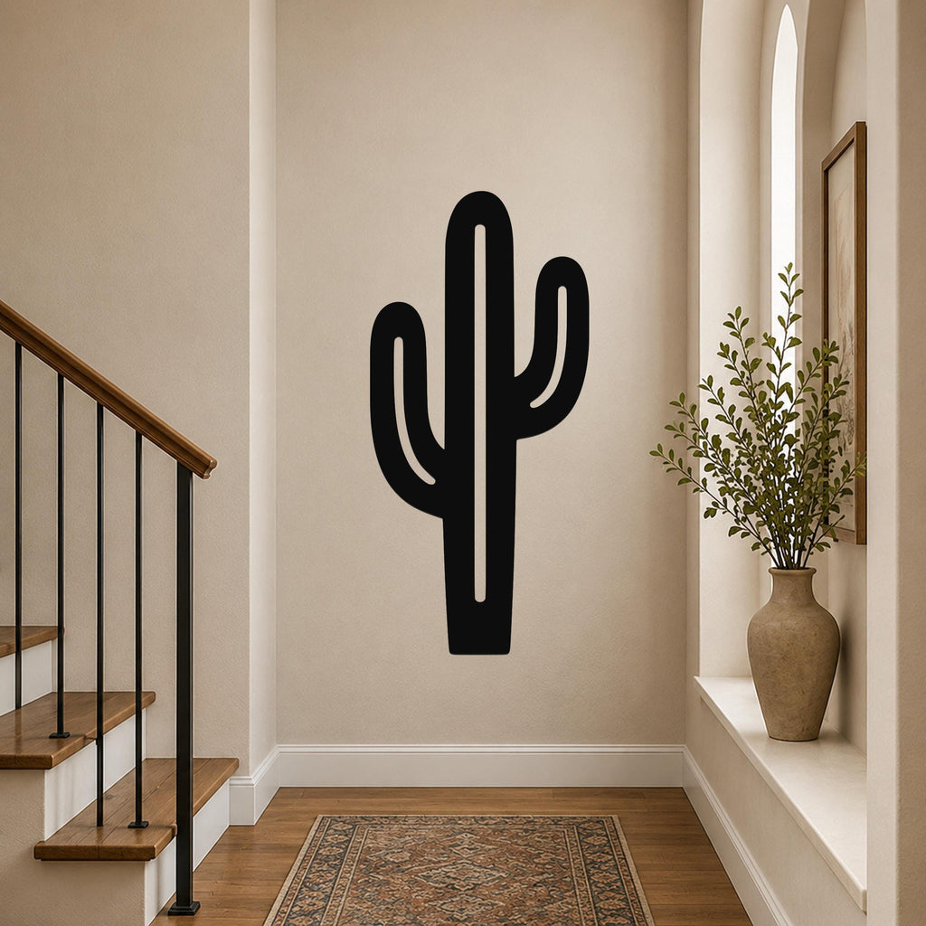 Black metal saguaro cactus wall art with cutout arms, mounted on a beige hallway wall above a patterned rug.
