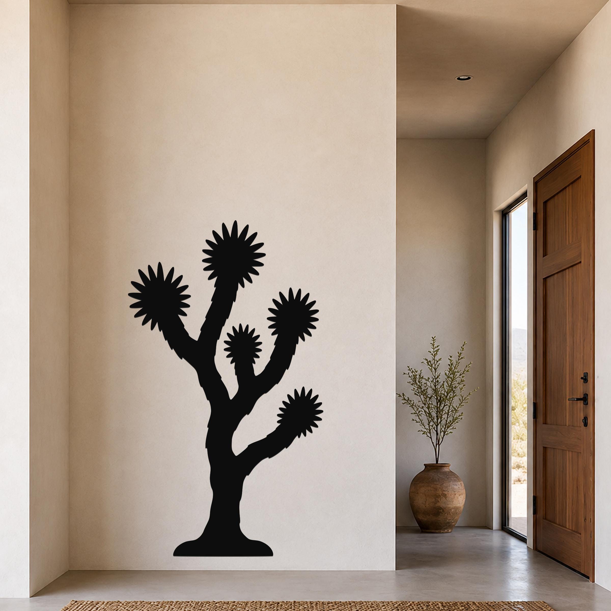 Black metal Joshua tree wall art with starburst-shaped branches, mounted on a beige wall in a modern entryway.